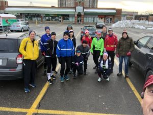 A group of runners and walkers posing for a picture prior to their workout. 